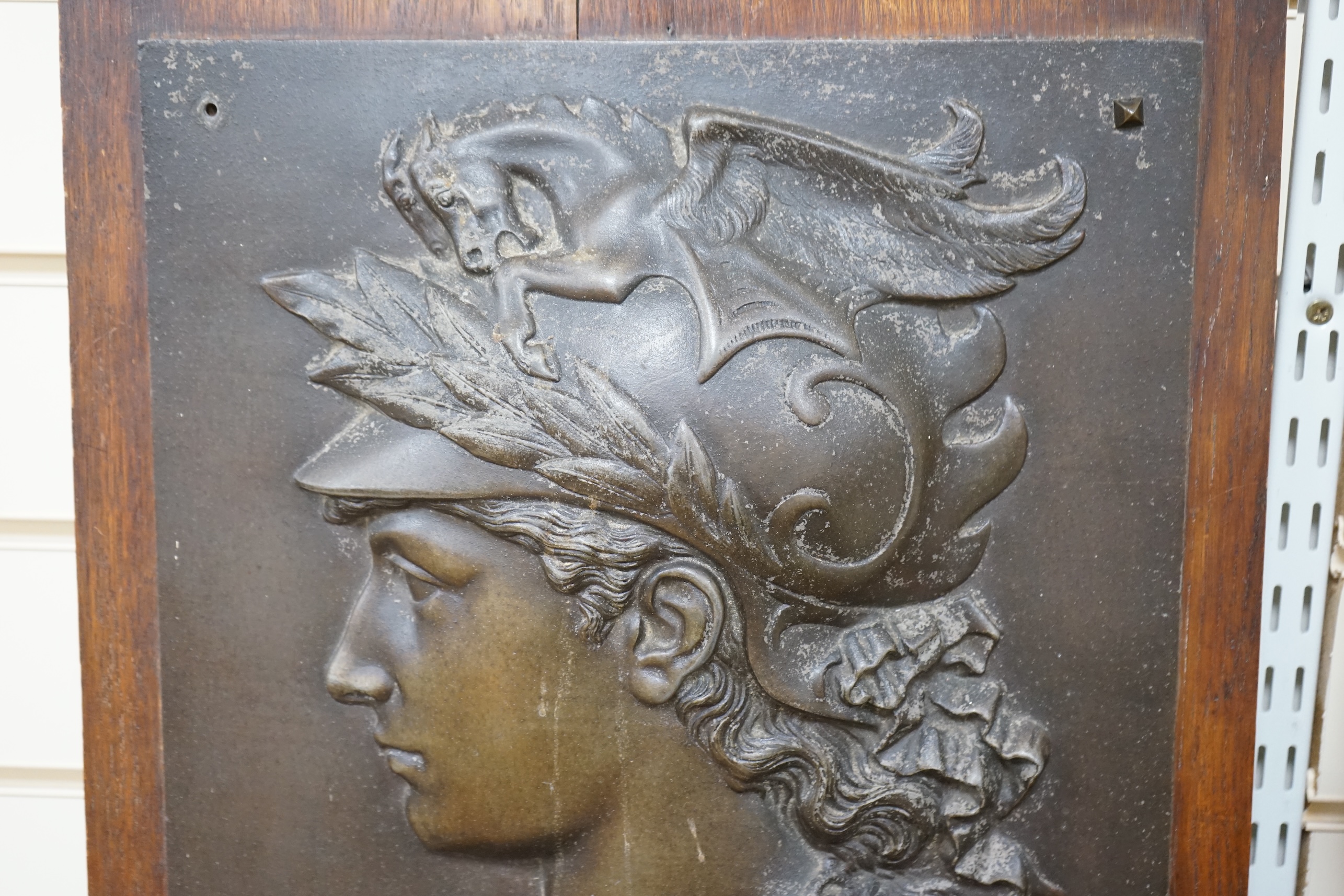 After Edmond Louis Charles Tassel (French, fl. 1870-1900), a bronzed metal bas-relief plaque with the bust of Perseus, mounted on an oak panel, circa 1900. Relief 49.5 cm high x 35cm wide. Condition - poor